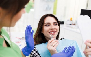 Woman smiling while getting dental veneers in Fair Oaks