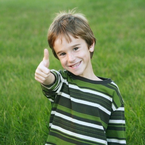 Child giving thumbs up after frenectomy lip and tongue tie treatment