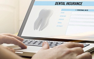 Person filling out a dental insurance form on a laptop