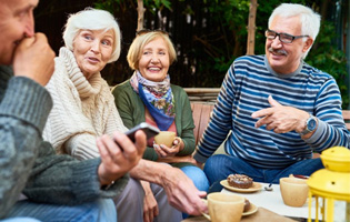 Group of friends chatting outside with breakfast