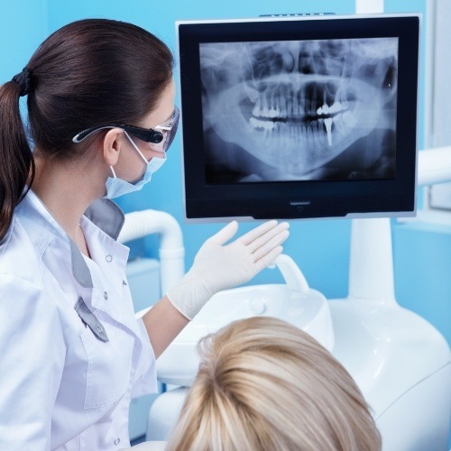 Dentist and dental patient looking at digital x rays on screen