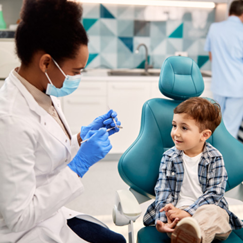 a dentist talking to a child sitting in a dental chair