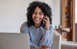 Woman smiling while talking on phone at home