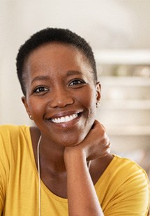 Woman in yellow shirt smiling in living room