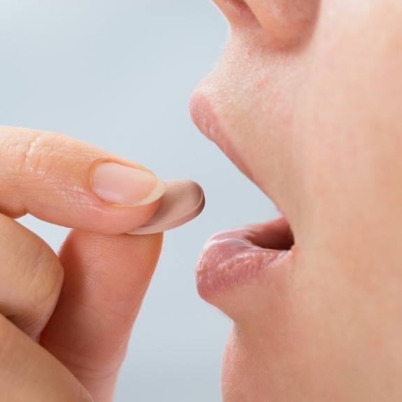 Dental patient taking an oral conscious sedation dentistry pill