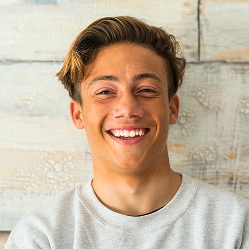Male teenager smiling after a frenectomy