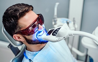 Man undergoing teeth whitening treatment in dental office