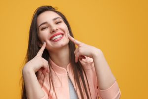 Happy woman pointing to her smile