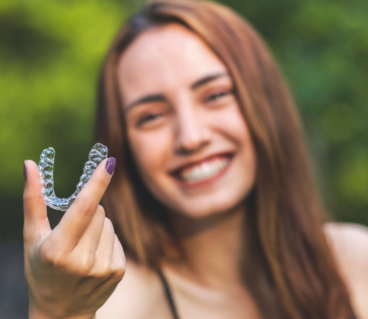Woman holding clear aligner